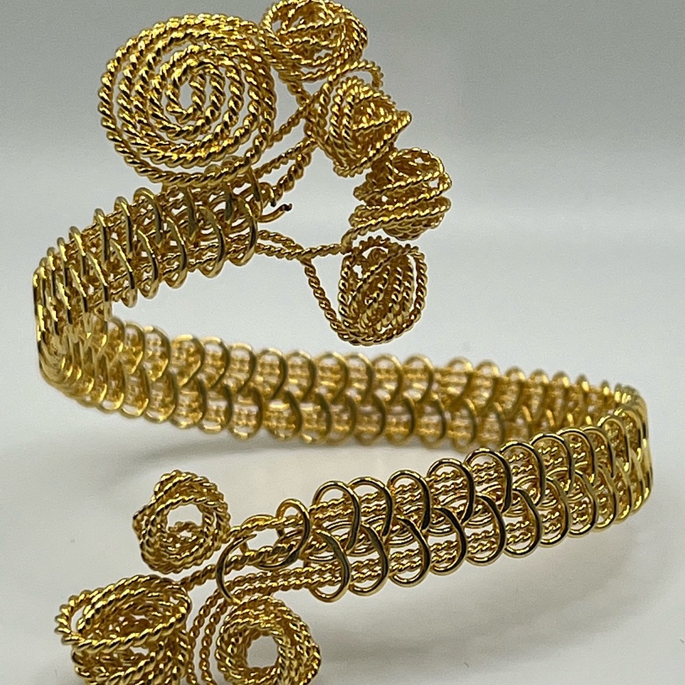 Gold-plated hand creating bracelet.
